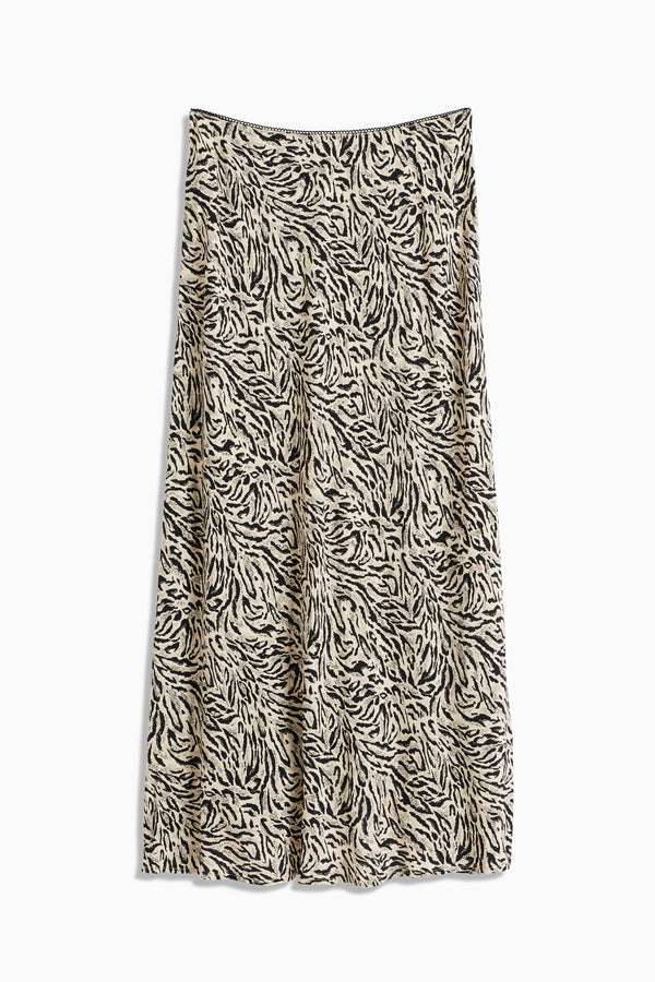 The Ardith - Sun Leo Tan is a beige A-line midi skirt with a black and white abstract tiger stripe print and an elasticated waistband, shown flat against a white background.