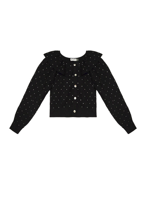 The Jelena - Crystal Black is a black long-sleeve pointelle-knit cardigan with white polka dots, front white buttons, and a large ruffled collar. Its classic and feminine design makes it an elegant choice for parties.