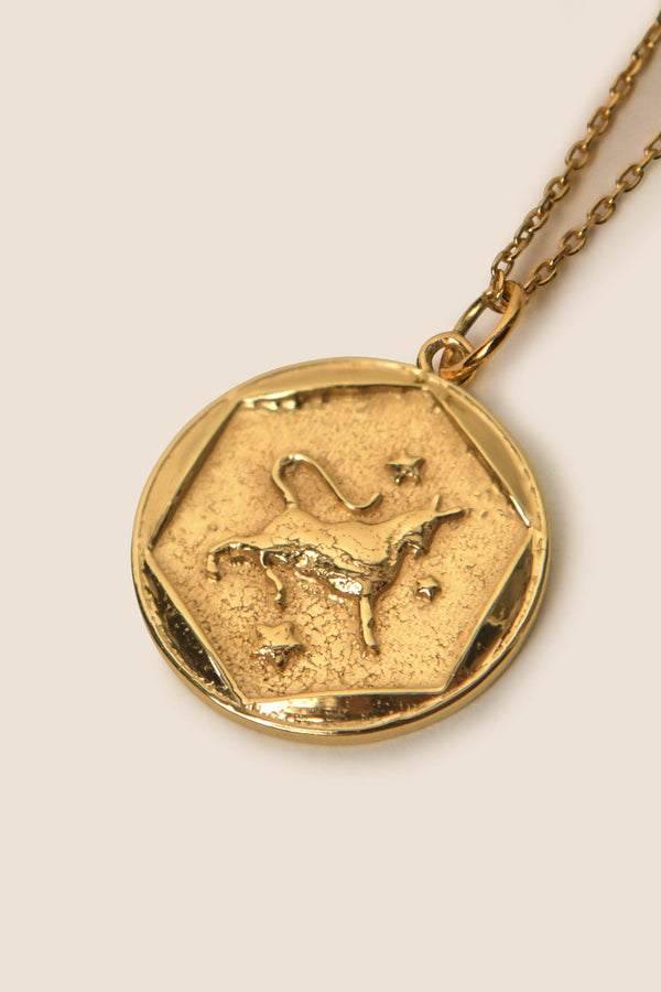A gold vermeil pendant necklace featuring an embossed image of a bull and stars, symbolizing the Taurus zodiac sign, on a textured hexagonal background—perfect for fans of zodiac necklaces.