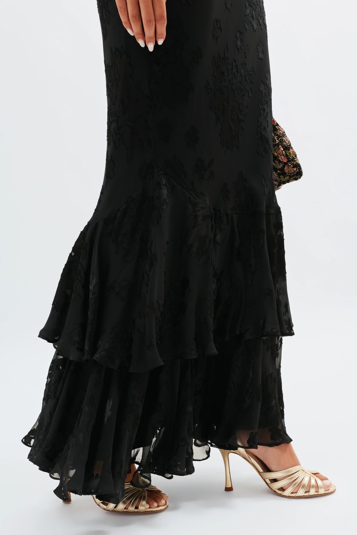 Wearing the Ordinia - Bouquet Devoré Black skirt with gold strappy heels and a patterned clutch, this look is effortlessly chic—perfect for black-tie weddings.