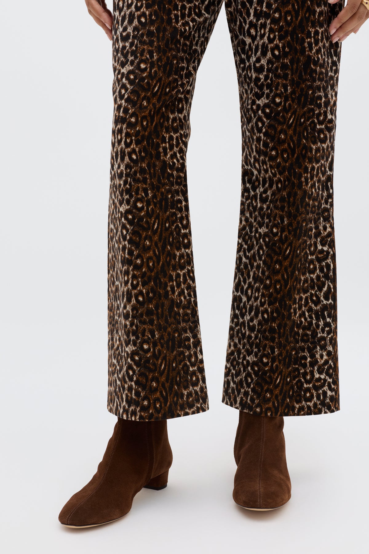 A person wearing brown ankle boots and the Olwen - Lyra Leopard Black flared vintage-inspired trousers, standing against a plain light background.