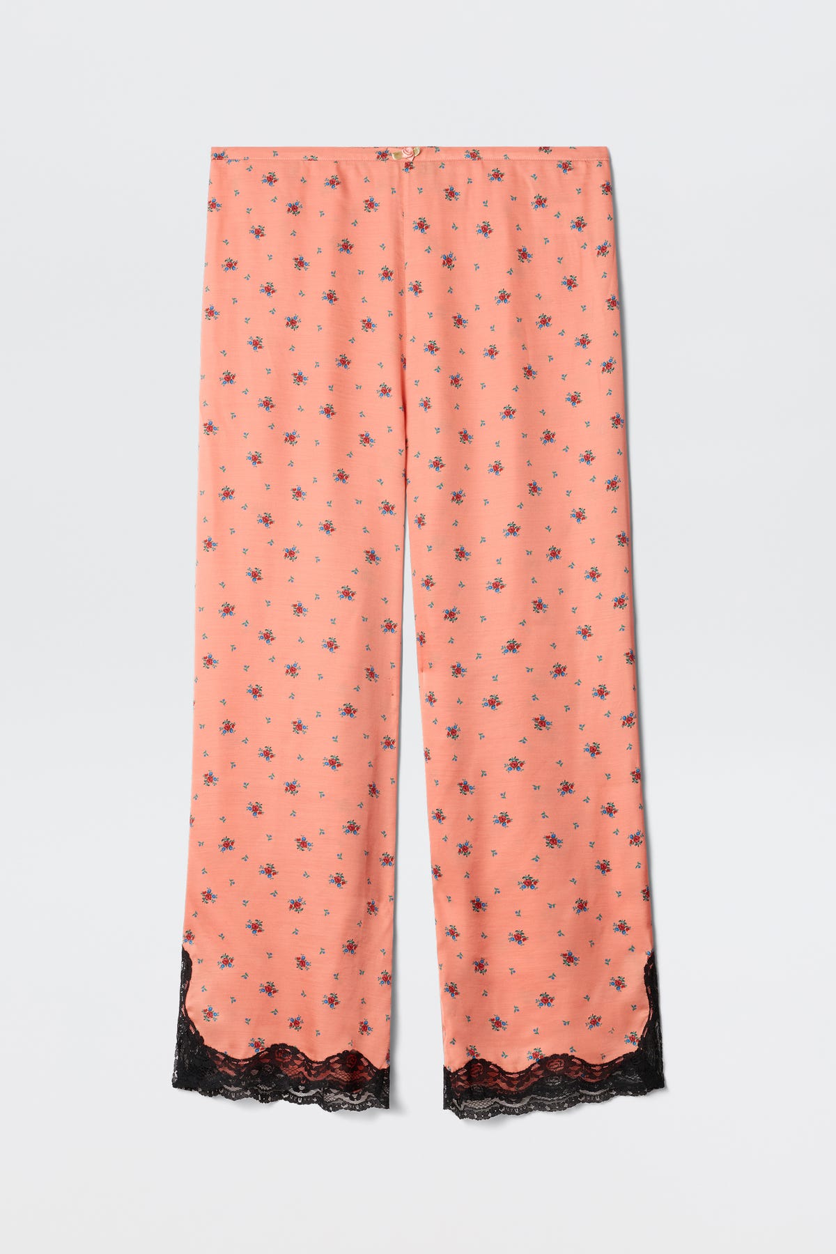 Mireille - Peonies Ditsy Coral pajama pants in coral pink, featuring a small black peony floral print and delicate black lace trim at the hem, displayed flat on a white background.