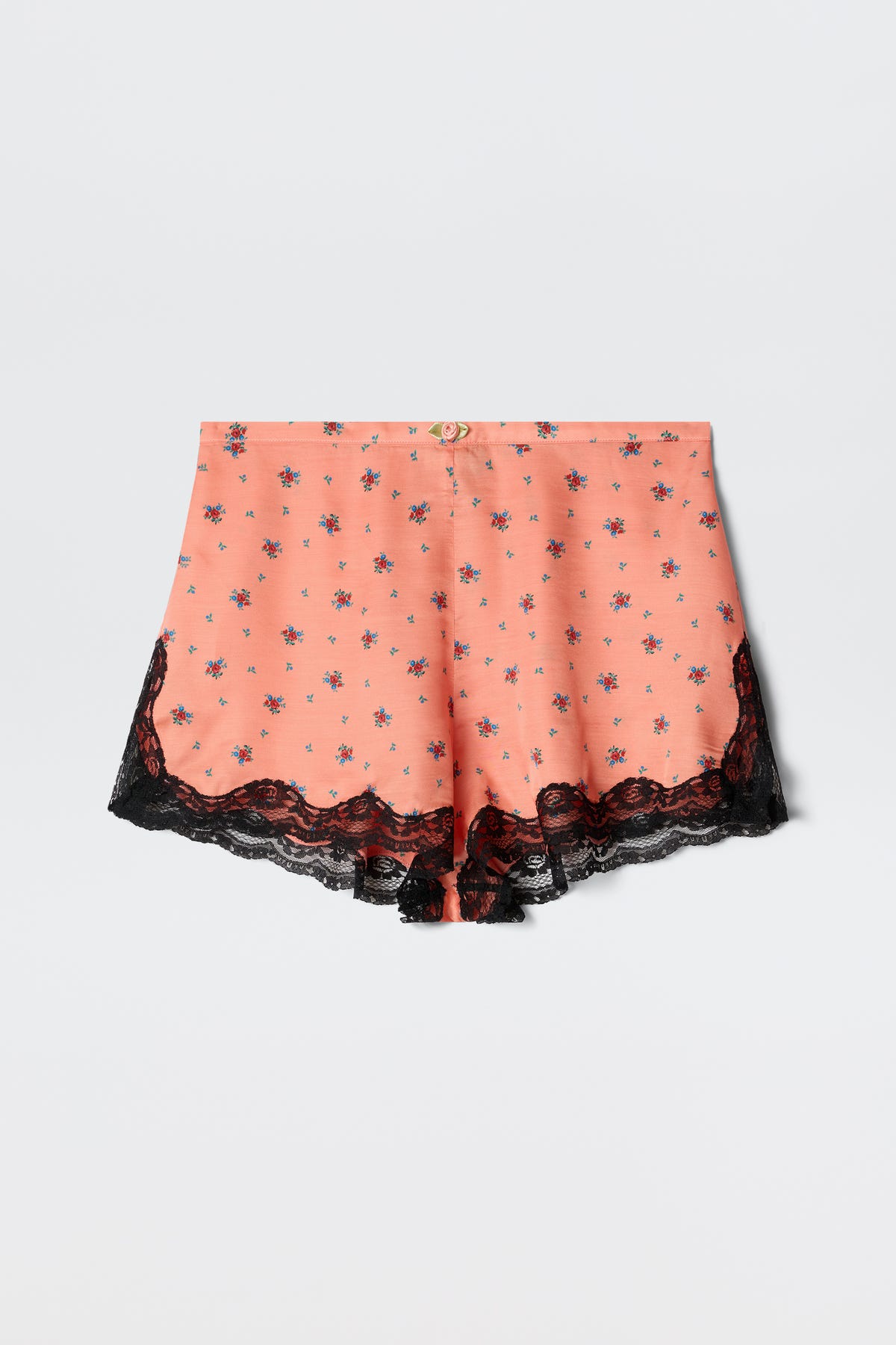 Lealia - Peonies Ditsy Coral women’s shorts in a peach hue with a small floral print and black lace trim along the hem, displayed on a plain white background.