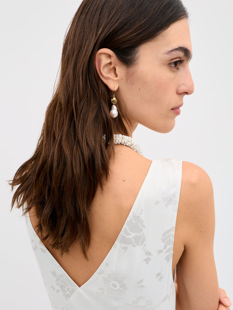 Woman wearing a white lace dress with a plain background