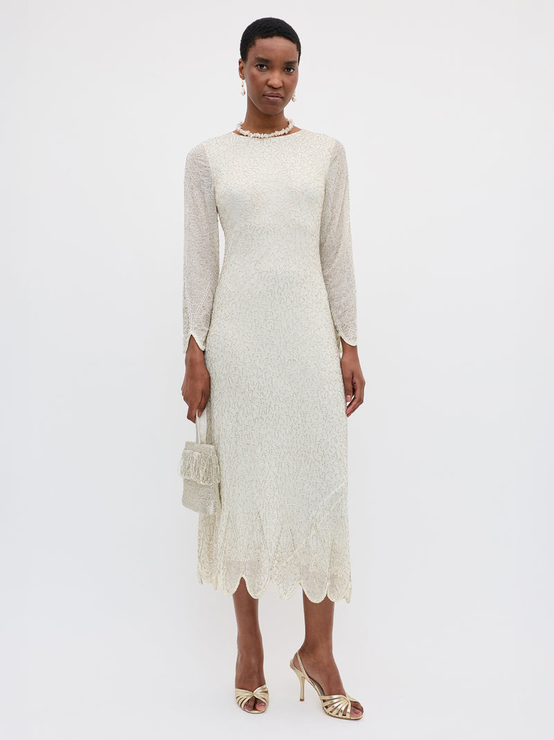 Woman wearing a white lace dress with long sleeves on a white background