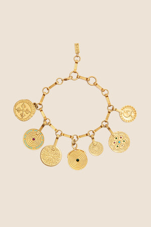 Adie - Gold is a bohemian bracelet with seven round, intricately designed golden pendants, some featuring colorful gemstone accents, shown on a beige background. Ideal for those who love vintage-inspired jewelry.