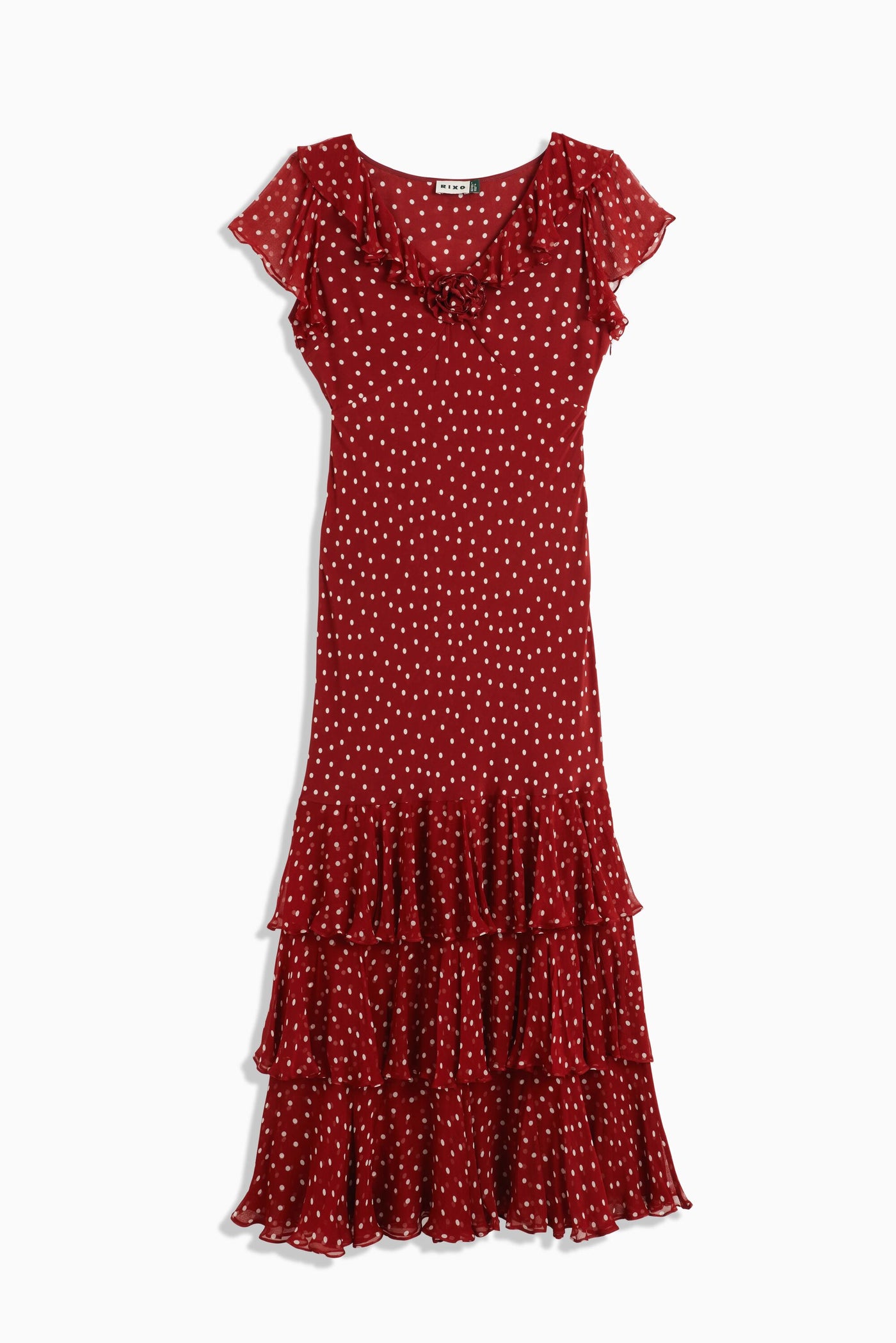 The Amelle Layla Dot Red is a classic ankle-length silk dress in red with white polka dots, featuring short sleeves, a ruffled neckline, and a layered ruffle hem.