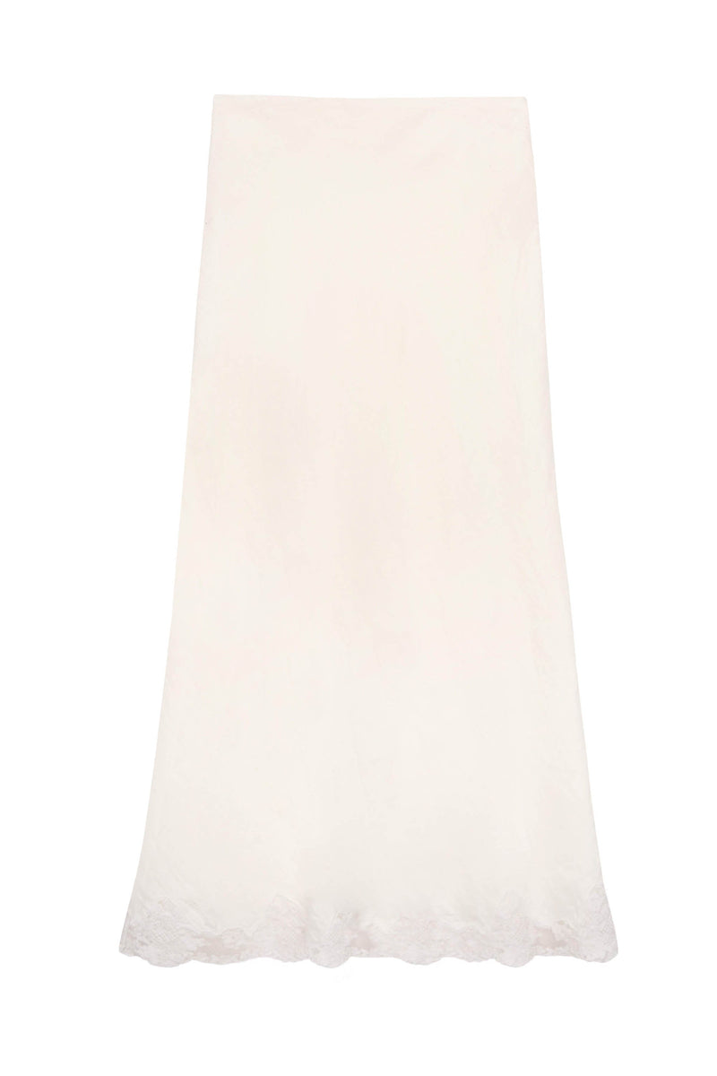 The Crystal - Cream is a long, cream midi slip skirt with a subtle floral pattern and delicate lace trim along the scalloped hem, shown against a plain white background.