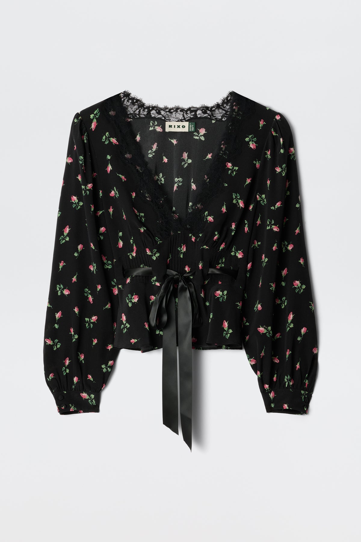 The Charis - Sienna Bud Black blouse by RIXO features black fabric with long sleeves, a delicate pink and green floral print, lace-trimmed deep V-neckline, and a wide satin ribbon bow at the waist for romantic femininity.