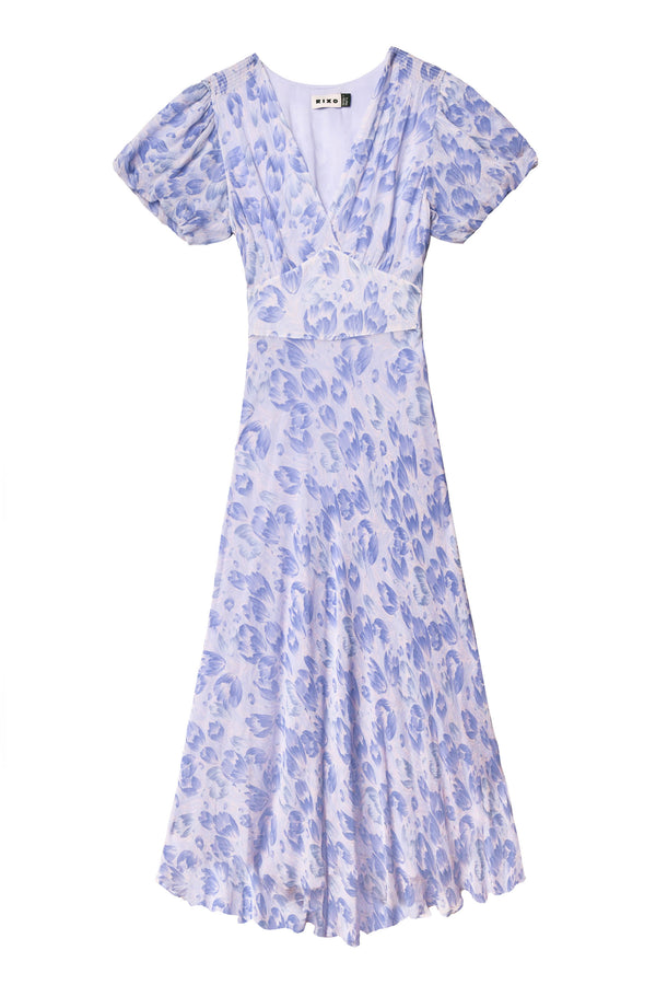 Perfect for summer events, the Corrine - Tulip Fields Cornflower Blue dress is a light purple midi with a v-neckline, short flutter sleeves, fitted waist, and gently flared skirt in a blue and lavender floral print.