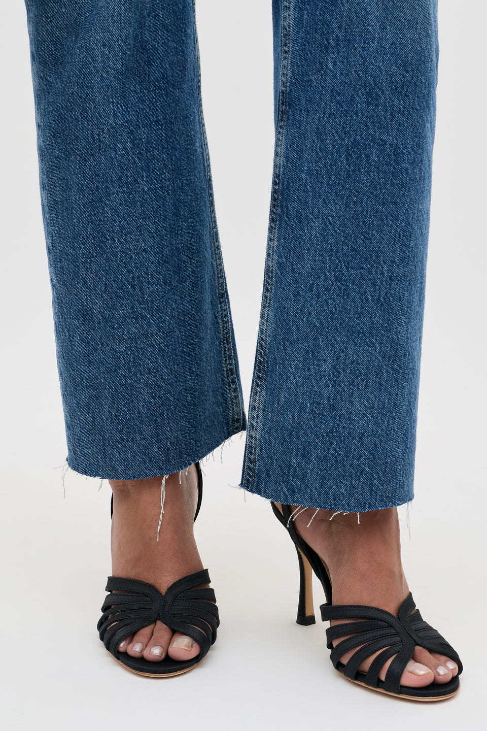 Mavi - Satin Black cropped blue jeans with a raw frayed hem worn with black strappy stiletto sandals.