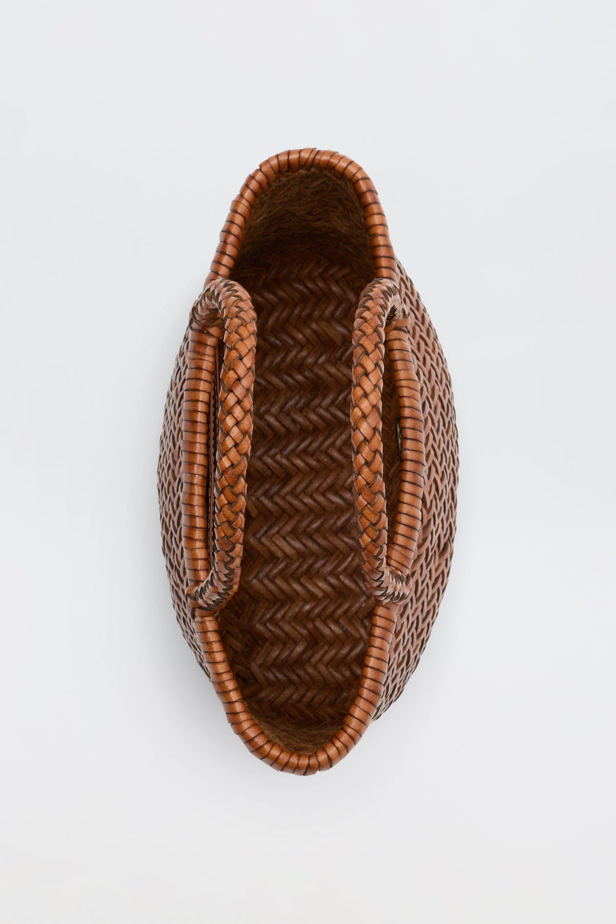 Lysia - Tan woven basket with two handles, viewed from above on a plain white background. Featuring a herringbone pattern and an oval shape, this basket is reminiscent of vintage woven bags.