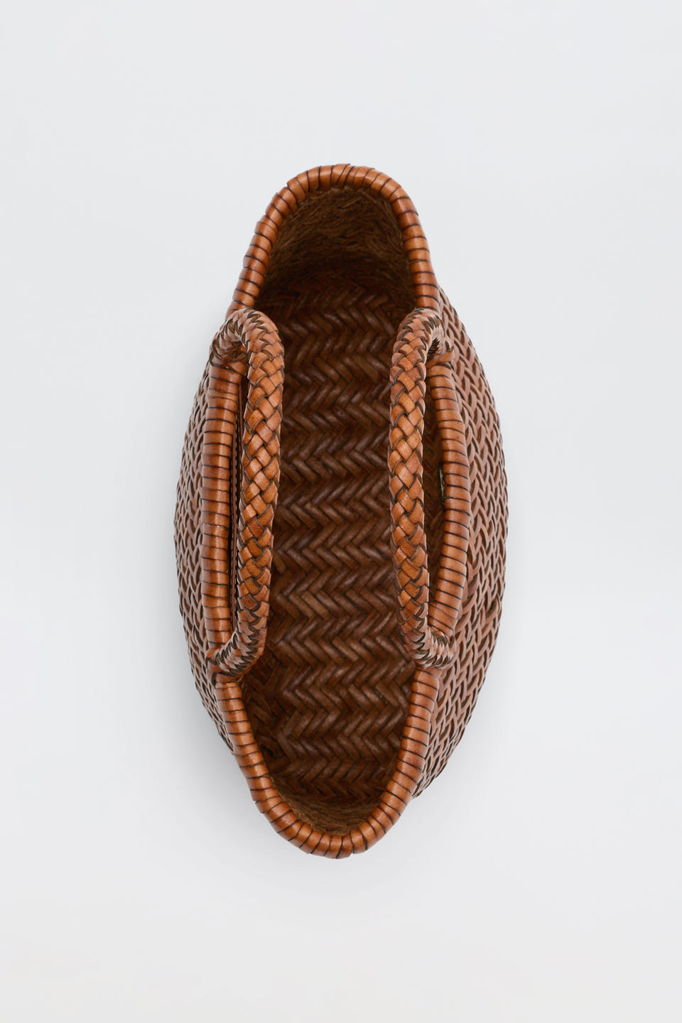 Lysia - Tan woven basket with two handles, viewed from above on a plain white background. Featuring a herringbone pattern and an oval shape, this basket is reminiscent of vintage woven bags.